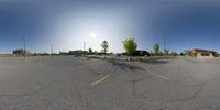 a fisheye view of a street with a car and tree in the distance and people walking nearby