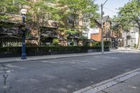 the sidewalk and street light is all empty, but there are lots of trees on both sides of it