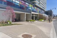 the building is very tall with many windows and plants on each corner and one door on the side