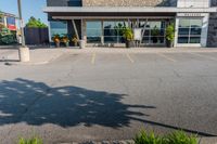 the parking lot of a building with a bunch of bushes outside of it's windows