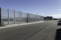 there are two vehicles parked in front of a large gated wall of fences at an airport