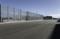 there are two vehicles parked in front of a large gated wall of fences at an airport