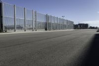 there are two vehicles parked in front of a large gated wall of fences at an airport