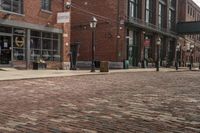 the sidewalk is lined with brick bricks, street signs and buildings in the city of a town