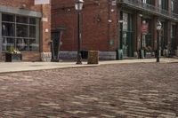 the sidewalk is lined with brick bricks, street signs and buildings in the city of a town