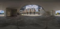 a picture looking through a fish eye lens at a large building in an empty parking lot