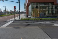 street signs and traffic lights in front of a building on street corner, with reflection of an old woman