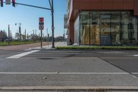 street signs and traffic lights in front of a building on street corner, with reflection of an old woman