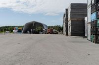 large wooden crates sitting in the middle of a parking lot near an airplane hangar with other equipment