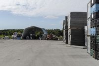 large wooden crates sitting in the middle of a parking lot near an airplane hangar with other equipment