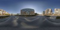 a panoramic photo of a city street intersection with buildings and a curved street