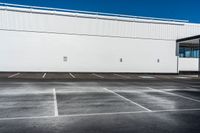 a building that is sitting on top of a parking lot while the sky has no clouds