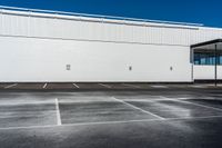 a building that is sitting on top of a parking lot while the sky has no clouds