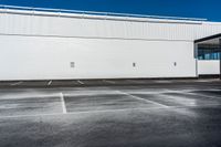 a building that is sitting on top of a parking lot while the sky has no clouds
