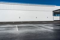 a building that is sitting on top of a parking lot while the sky has no clouds