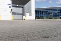 a parking lot in front of a large commercial building with a small motorcycle parked near it