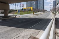 an empty street with tall buildings on each side of it, along with other tall buildings in the distance