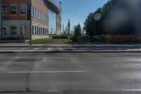 a empty parking lot at the intersection of two buildings and the road in front of it