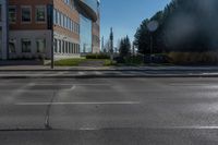 a empty parking lot at the intersection of two buildings and the road in front of it