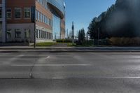 a empty parking lot at the intersection of two buildings and the road in front of it