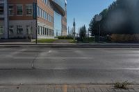 a empty parking lot at the intersection of two buildings and the road in front of it