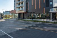 the two story hotel building on this street has a glass walkway that leads to the entrance