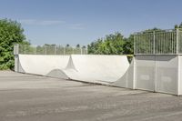 an empty parking lot with a skate board ramp to it and some trees in the background