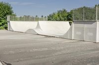 an empty parking lot with a skate board ramp to it and some trees in the background