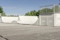 an empty parking lot with a skate board ramp to it and some trees in the background