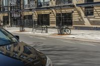 a car sitting outside of a building on the street corner next to a parked bike