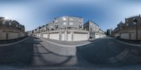 a panoramic view of an intersection with a lot of buildings and a blue sky