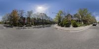 an image of a wide angle shot of the street and homes in a small city