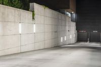 the large concrete wall has been illuminated by recessed lights at night on either side of it