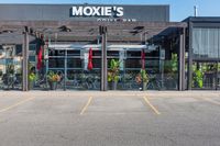 an empty building with red flags hanging on the front and outside of it and there are large green plants in the foreground