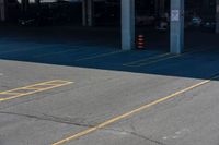 an empty parking lot with yellow signs and yellow cones on the pavement and yellow markings in the parking spaces