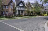 the suburban home is on the street in front of the big brick house and its landscaping