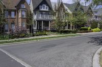 the suburban home is on the street in front of the big brick house and its landscaping