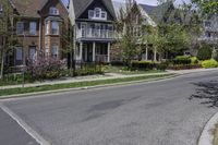 the suburban home is on the street in front of the big brick house and its landscaping