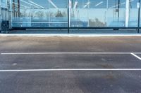 an empty parking lot with a clear glass window in the background while someone takes a picture