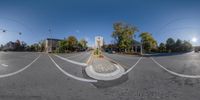 a 360 - lens picture of a parking lot with an intersection and traffic lights in the background