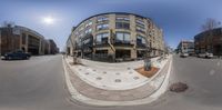 a fish - eye lens picture of a street corner with several buildings on either side of the road