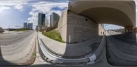 a 360 - fisheye view of some buildings next to a highway and street lights