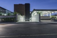 empty parking lot with illuminated walkway and building in background at night time or daylight with no people around