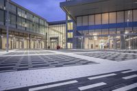 the entrance of a glass building on a very busy day that is empty at night