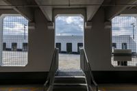 a ramp going up the side of a train car ramp with a passenger loading station to the left of the gate