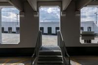 a ramp going up the side of a train car ramp with a passenger loading station to the left of the gate