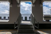 a ramp going up the side of a train car ramp with a passenger loading station to the left of the gate