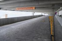 a walkway is empty with a sign in the middle of it that reads upper level parking