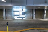 a empty parking garage with some empty floor space and a long building entrance way with no windows