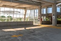 a large parking garage with an open roof and large glass windows in it's middle